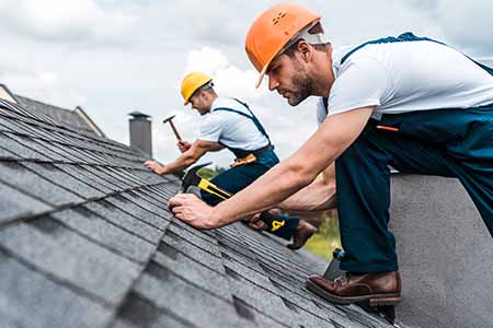 roofers installing asphlt shingles to roof